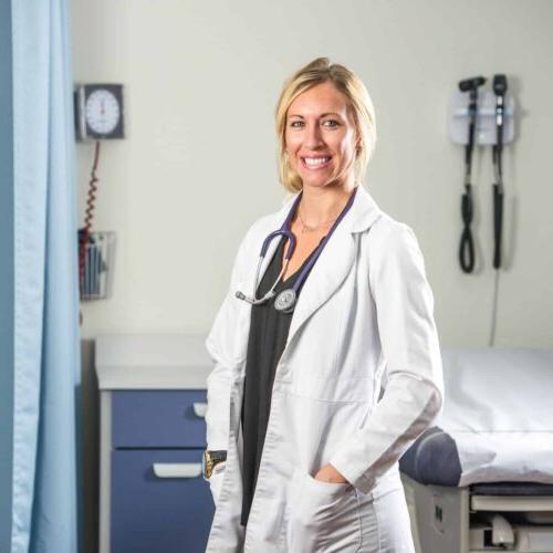 Smiling Nurse by a medical bed.