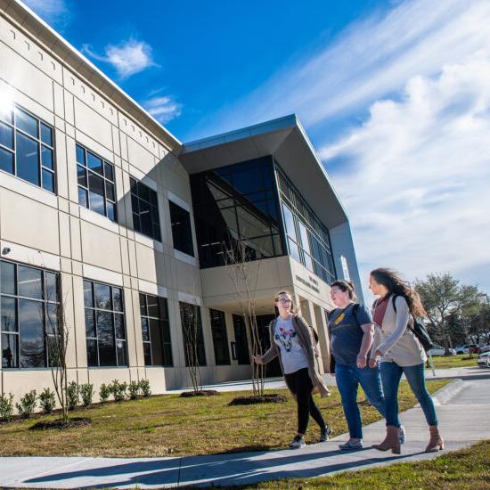 Three students walking on the mesquite campus.