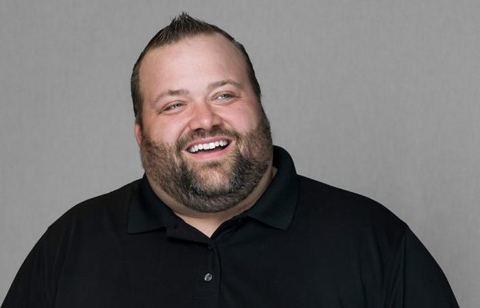 A man poses against a gray background.