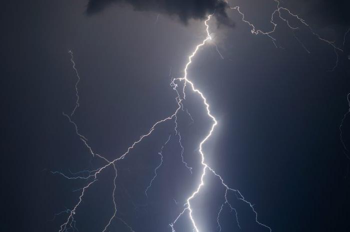 Lightening branches across a stormy, dark grey sky.